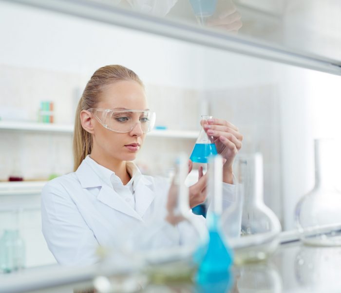 Young female testing new substance in chemistry lab